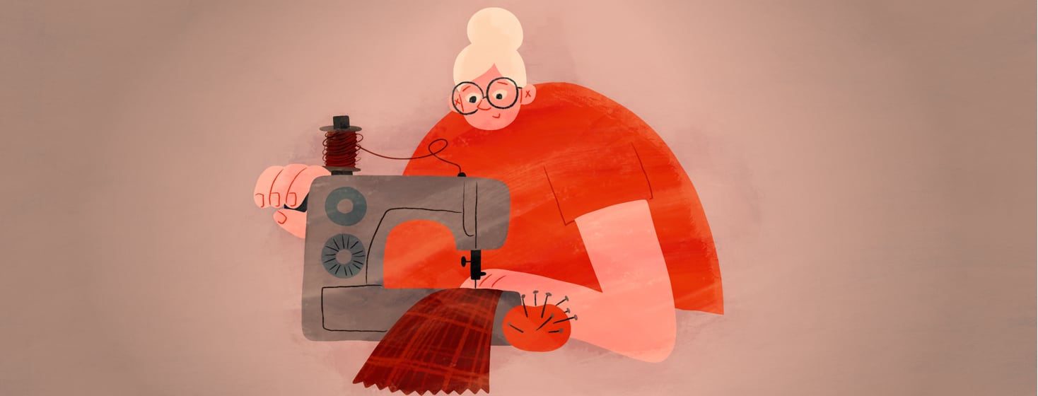 A woman sits at her sewing machine.